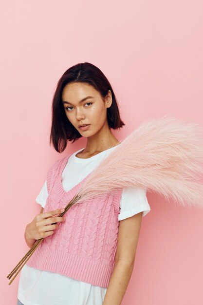 Short haired brunette in a pink vest with feathers in his hands Lifestyle unaltered