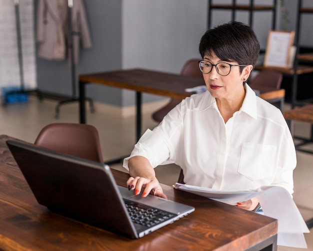 Short haired business woman working on laptop