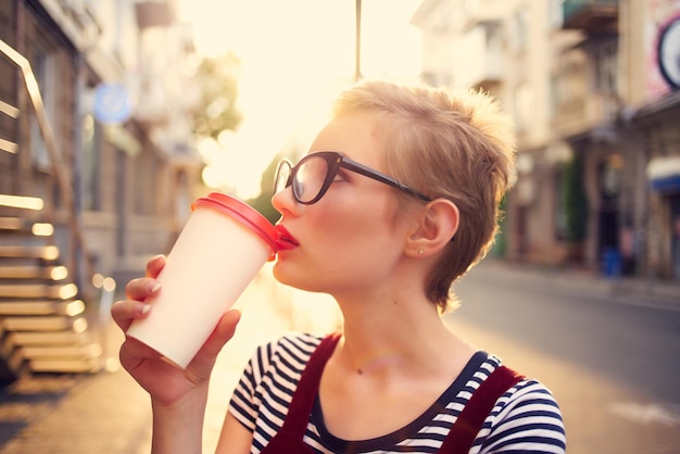 Foto donna dai capelli corti all'aperto tazza con drink passeggiata estiva