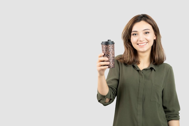 Short-haired young girl with cup of latte standing and posing. High quality photo