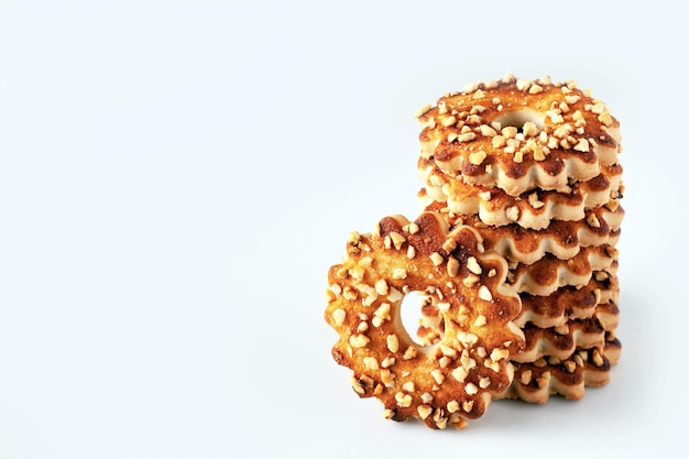 Shortbread cookies in the shape of a flower sprinkled with nuts on a white background copy space