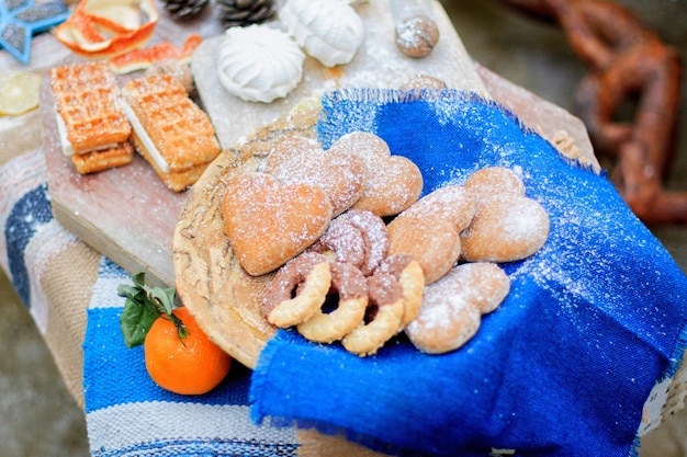 Shortbread cookies in the shape of a heart, lie on a blue cloth in a baske