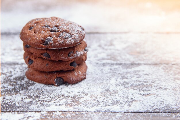 Shortbread cookies with chocolate chips on wooden  sprinkled with powdered sugar. Fresh pastry. Oatmeal cookies for dessert.