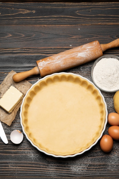 Shortbread dough for baking quiche tart and ingredients in baking form