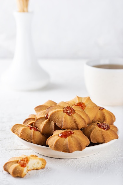 Shortbread kurabye in plaat met kopje thee op witte boterkoekjes voor Chinees Nieuwjaar