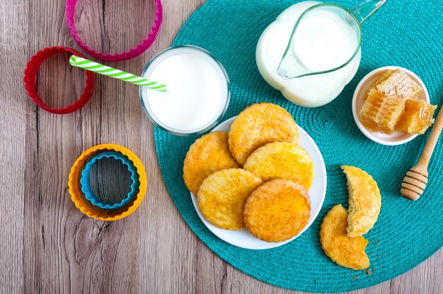 Shortbread milk cookies on a plate, milk and honey.