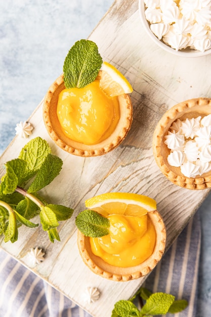 Shortbread taartje gevuld met lemon curd munt en schijfjes citroen en mini meringue