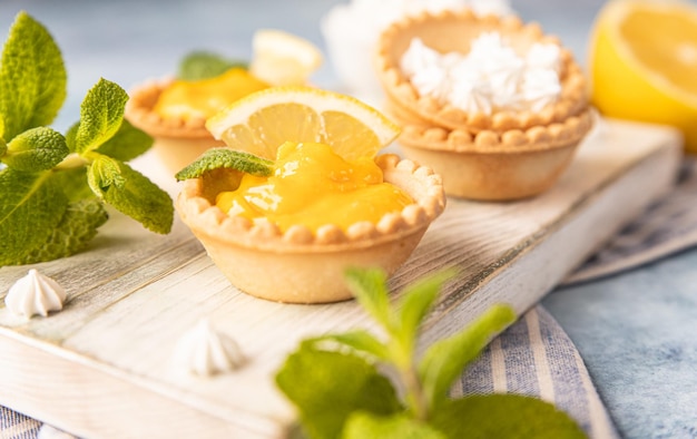 Photo shortbread tartlet filled with lemon curd mint and lemon slices and mini meringue