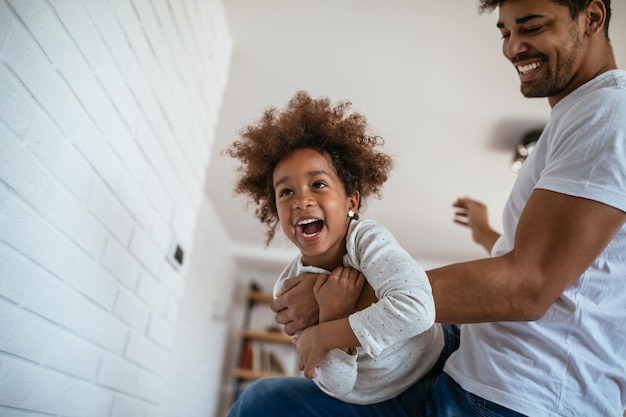 Shot of african american father and daughter having fun together at home