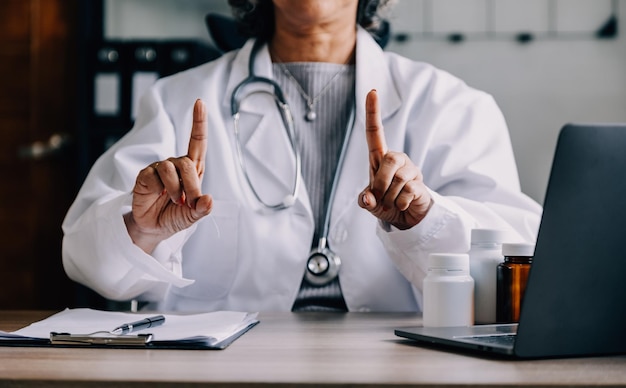 Shot of attractive female doctor working with her computer in medical consultation