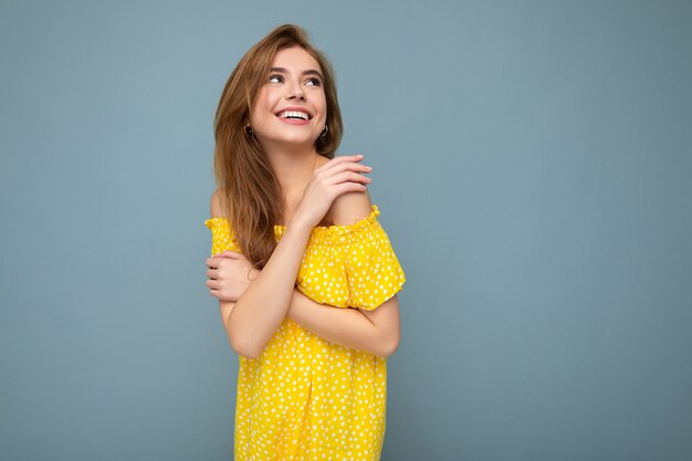 Shot of attractive happy smiling young woman wearing casual outfit standing isolated over colourful background