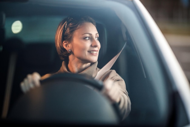 彼女の車を運転している魅力的な成熟した女性のショット。