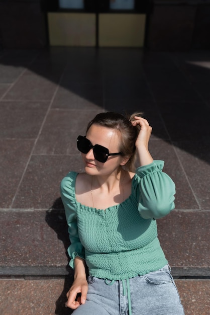 Shot of an attractive young woman sitting alone on the steps and looking away