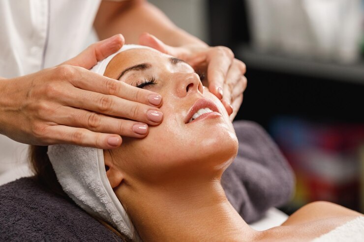 Photo shot of a beautiful young woman enjoying face massage at the beauty salon.