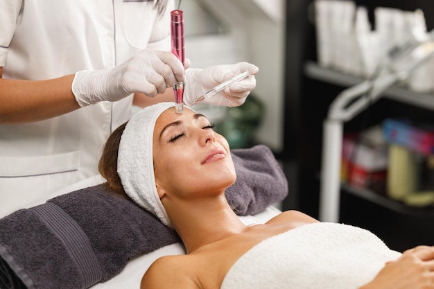 Shot of a beautiful young woman on a facial dermapen micro-needling treatment at the beauty salon.