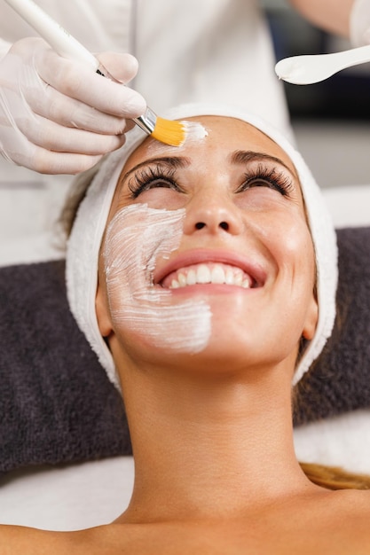 Photo shot of a beautiful young woman getting a facial mask treatment at the beauty salon.