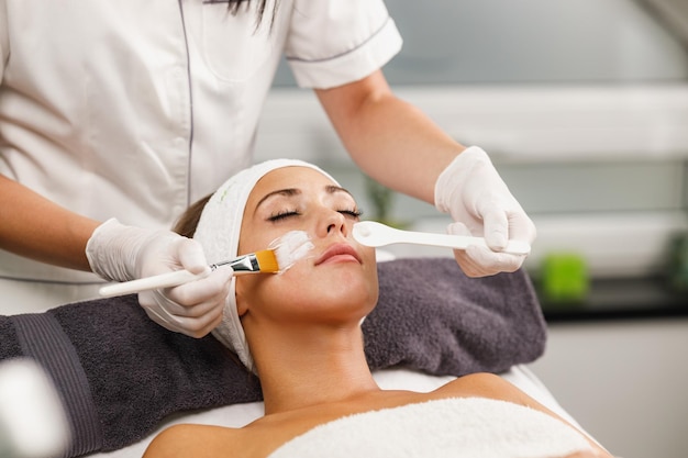 Shot of a beautiful young woman getting a facial mask treatment at the beauty salon.