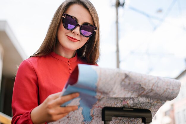 Shot of a beautiful young woman traveler in sunglasses with a map