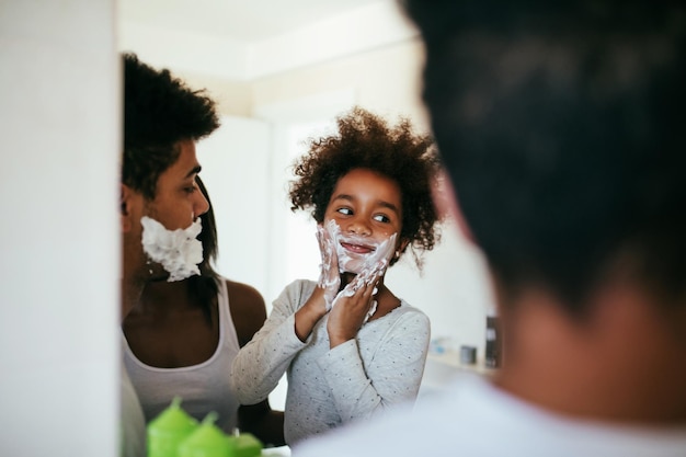 Shot of black family having fun in the bathroom with shaving foam