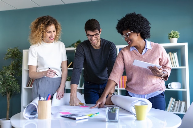 Shot of casual young entrepreneurs working and talking of their new business together in the office.