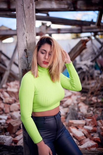 shot of a Caucasian woman wearing a bright top in an abandoned building with graffit