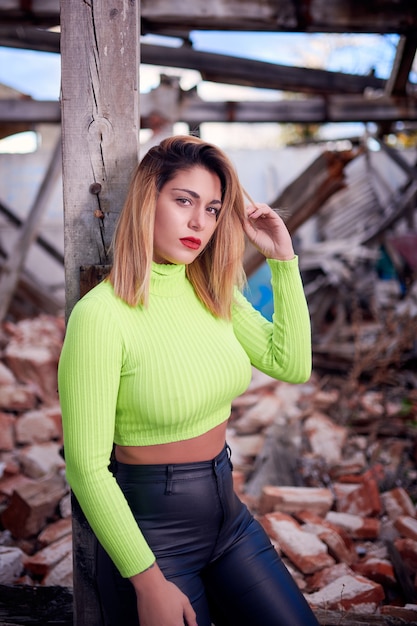 shot of a Caucasian woman wearing a bright top in an abandoned building with graffiti