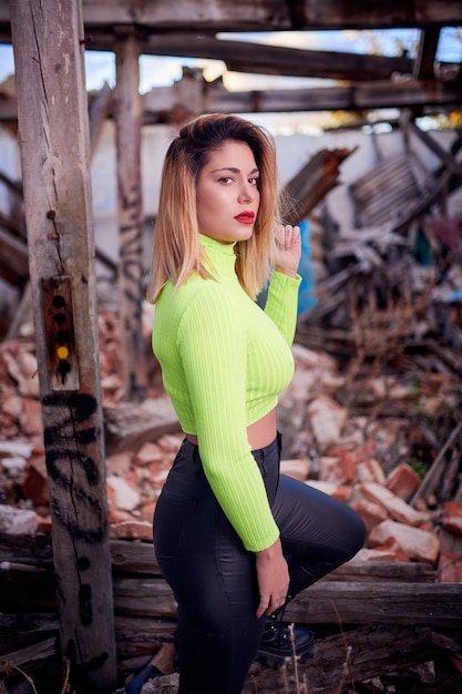 shot of a Caucasian woman wearing a bright top in an abandoned building with graffiti