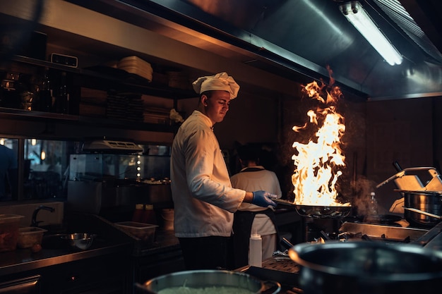 Foto scatto di uno chef che cucina in una cucina professionale