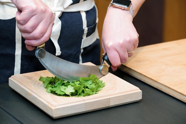 Shot of chef's hands cutting greens