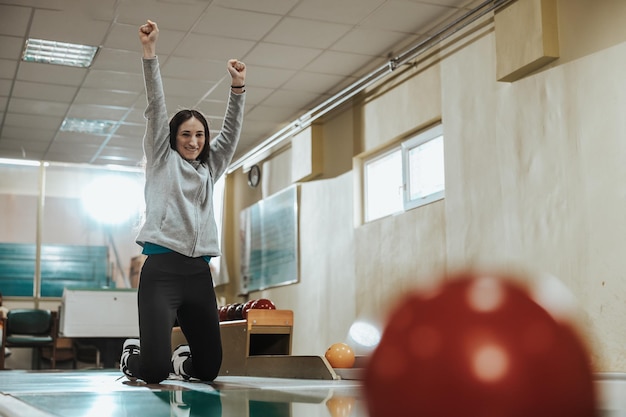 Shot of a cute girl celebrating at the bowling club.