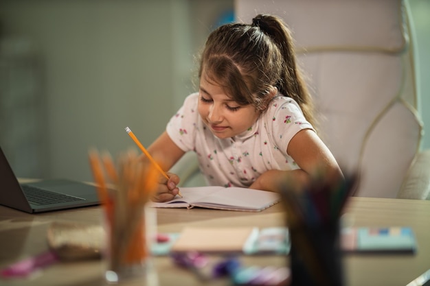 Shot of a diligent little girl doing a homework assignment at home during COVID-19 pandemic.