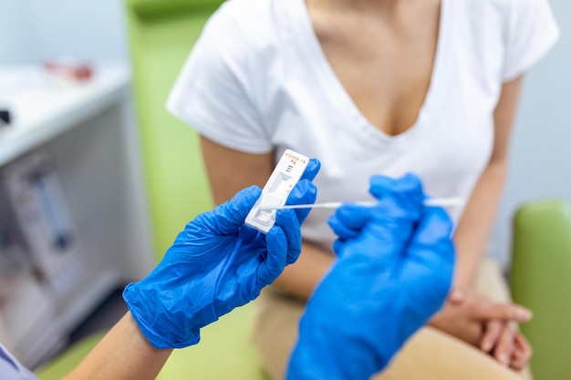 Shot of a doctor using cotton swab while doing coronavirus PCR test at the hospital