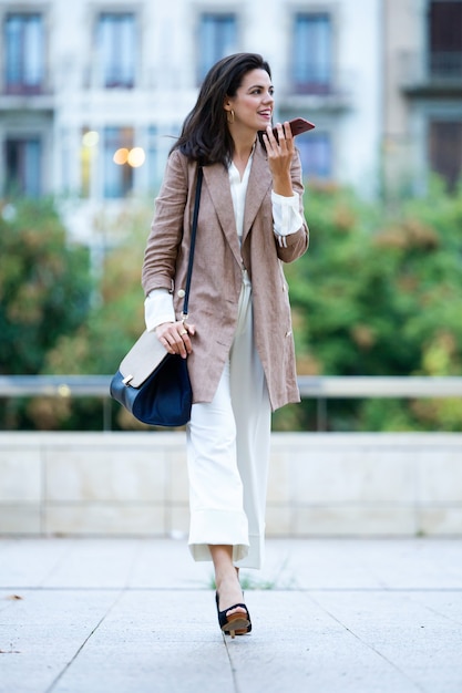 Shot of fashion young beautiful businesswoman talking with her mobile phone in the street.