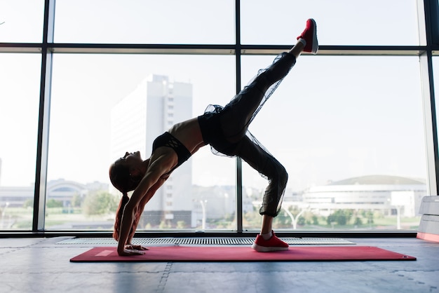 Shot of fitness woman on exercise mat. Female athlete lying on her back after a gym workout