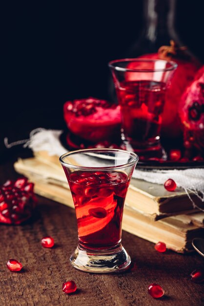 Shot glass of pomegranate tincture with fresh fruit