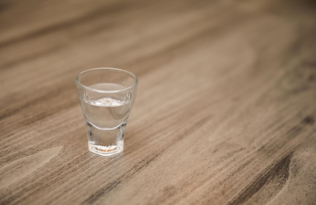 A shot glass with a few empty vodka in it