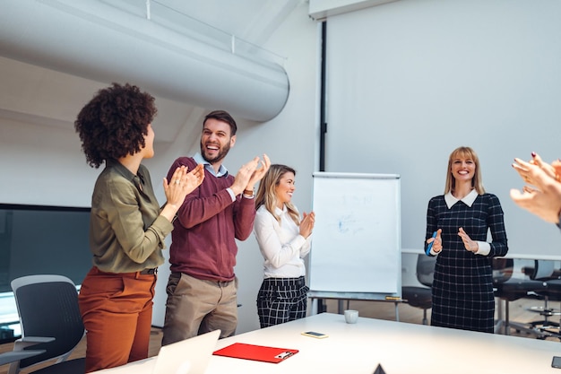 Shot of a group of coworkers applauding after a successful presentation in a boardroom