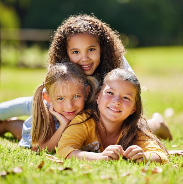 Photo .. shot of a group of kids laying on the grass outside.