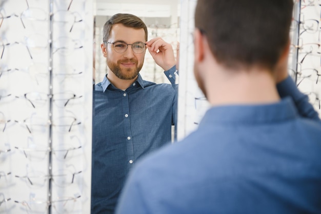 Photo shot of a handsome bearded man trying on new glasses at the eyewear storeman buying glasseshealth eyesight vision fashion shopping