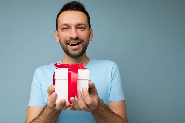 Shot of handsome happy smiling brunette unshaven young male person isolated over blue background