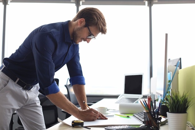 Shot of a handsome male architect working on a design in his office.