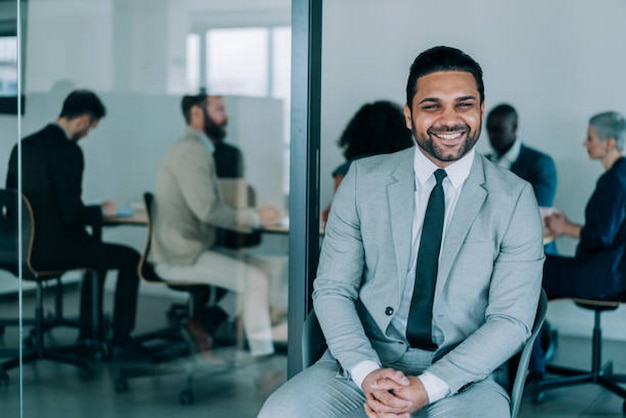 Shot of a handsome smiling businessman standing in front of his team in the office