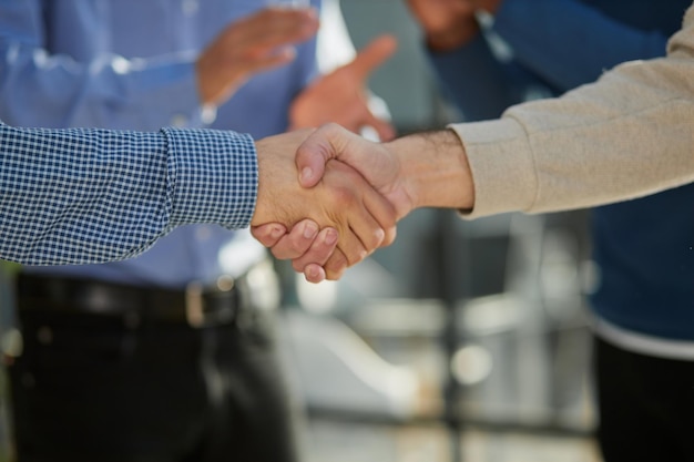 Shot of a happy businessman welcoming his new colleague to the team during a meeting in the boardroo