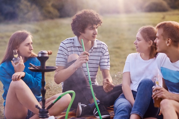 Shot of happy classmates smoke hookah