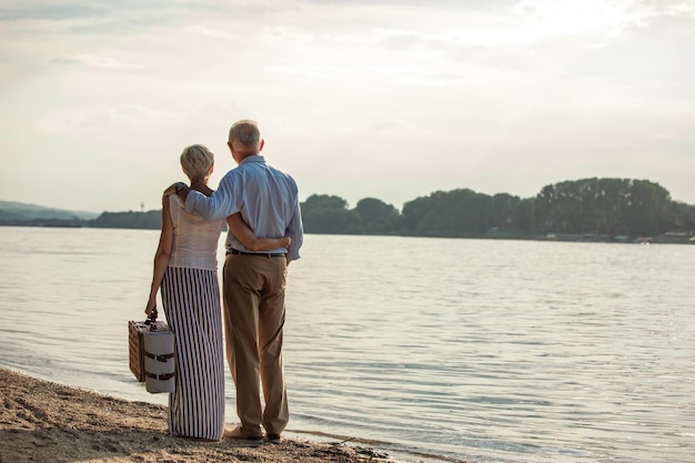 Shot of a happy senior couple going to picnic at the riverbank