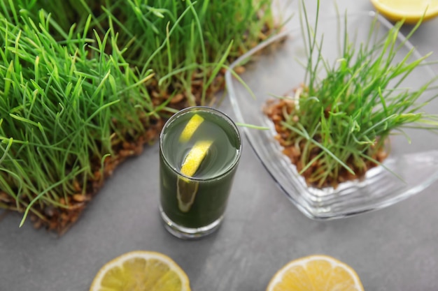 Shot of healthy juice and sprouted wheat grass on table