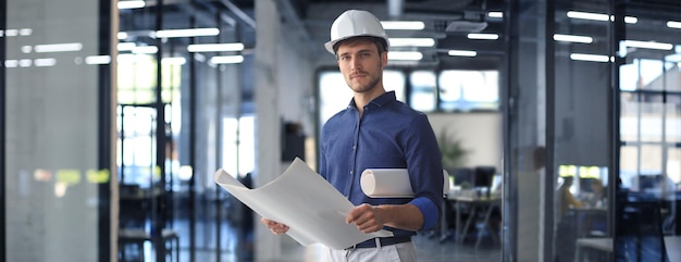 Shot of male architect wearing hardhat and inspecting new building