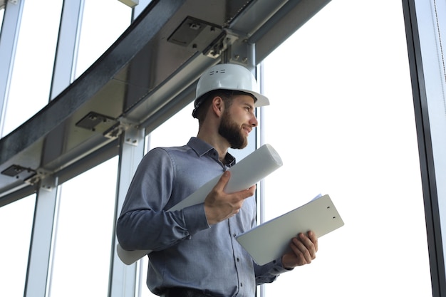 Shot of male architect wearing hardhat and inspecting new building.