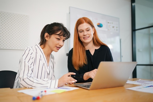 Shot of a mature businesswoman sitting and training her team in the office