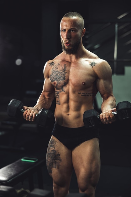 Shot of a muscular bodybuilder doing hard training with dumbbell at the gym.